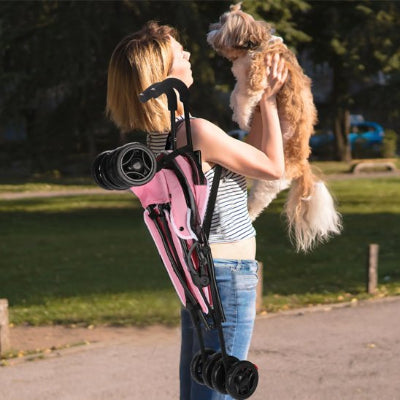 poussette pour Chien rose pliée sur le maßtre chien souleve dans ses bras